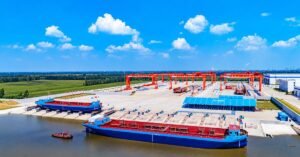 China Targets Doubling New Energy Inland Vessels by 2028 Under 2026-2030 Action Plan Summary China's Ministry of Transport, Ministry of Industry and Information Technology and National Energy Administration have issued a 2026-2030 action plan to scale up new energy vessels on inland waterways. It aims to double the fleet from 2025 levels by 2028, build methanol refuelling along the Yangtze and charging networks in the Yangtze River Delta, and create a 3,000 km zero-carbon waterway corridor. Article Beijing: China has issued a five-year roadmap to accelerate the adoption of new energy vessels on its inland waterways, with a focus on electric and methanol-powered ships. The Ministry of Transport, the Ministry of Industry and Information Technology and the National Energy Administration jointly released the Action Plan for the Promotion and Application of New Energy Inland Waterway Vessels (2026-2030), according to China Transportation News Network. What does the plan aim to do? The plan seeks to support the restructuring of China's industrial, energy and transport sectors. It combines a market-led approach with government guidance, and focuses on scenario-driven deployment and innovation. Building on the existing growth of LNG-powered vessels, the plan prioritises the full-scenario application, supply chain support and high-standard development of electric and methanol-powered inland ships. How big is China's new energy inland fleet? China ranks among the world leaders in the scale and application of new energy inland vessels. By the end of 2025, it had more than 1,200 new energy and clean energy vessels operating on inland waterways, including several high-tech vessels. What are the targets? The plan sets phased goals: By 2028: • Double the number of new energy inland vessels compared with 2025 • Achieve initial full-scenario demonstration applications • Fully establish methanol refuelling services along the Yangtze River main line • Largely complete charging and battery-swapping facilities for vessels across the Yangtze River Delta waterway network • Largely complete the "two horizontal and one vertical" green shipping channels and pilot zones for vessel electrification, forming a 3,000 km zero-carbon waterway transport corridor By 2030: • Achieve initial large-scale application of new energy vessels What are the key tasks? The plan sets out 11 key tasks, including: • Promoting multi-scenario use of new energy ships • Improving energy supply security • Encouraging innovative business models • Strengthening shipbuilding and manufacturing support • Optimising operation and management • Improving standards, regulations and supervision • Strengthening research on key technologies It also calls for stronger policy support, pilot projects and organisational implementation. How does it fit China's wider fuel transition? The plan complements China's rapid build-out of alternative fuel bunkering at its coastal ports. Guangzhou Port recently completed its first terminal-based green methanol bunkering for a COSCO 16,000-TEU container ship, while Ningbo-Zhoushan has carried out LNG, methanol and biofuel bunkering on the same day. Why does it matter? China's inland waterways, led by the Yangtze, form the world's busiest river freight system. Electrifying and converting this fleet to methanol at scale would cut emissions from a major source of domestic freight, while building large markets for marine batteries, charging infrastructure, methanol engines and green fuel supply. The plan is also relevant for India, which is expanding cargo movement on its National Waterways and has started deploying clean-energy vessels, including a hydrogen fuel cell inland waterway vessel built by Cochin Shipyard under the Harit Nauka initiative. China's approach, which pairs fleet targets with refuelling, charging and standards, offers a model for scaling green inland shipping. FAQs Who issued China's new energy inland vessel action plan? The Ministry of Transport, the Ministry of Industry and Information Technology and the National Energy Administration. How many new energy inland vessels did China have by end-2025? More than 1,200 new energy and clean energy vessels. What is the 2028 target? To double the number of new energy inland vessels compared with 2025 and form a 3,000 km zero-carbon waterway corridor. Which fuels does the plan prioritise? Electric and methanol power, building on existing LNG-powered vessels. How many key tasks does the plan include? Eleven, covering vessel deployment, energy supply, business models, manufacturing, operations, standards, supervision and technology research.